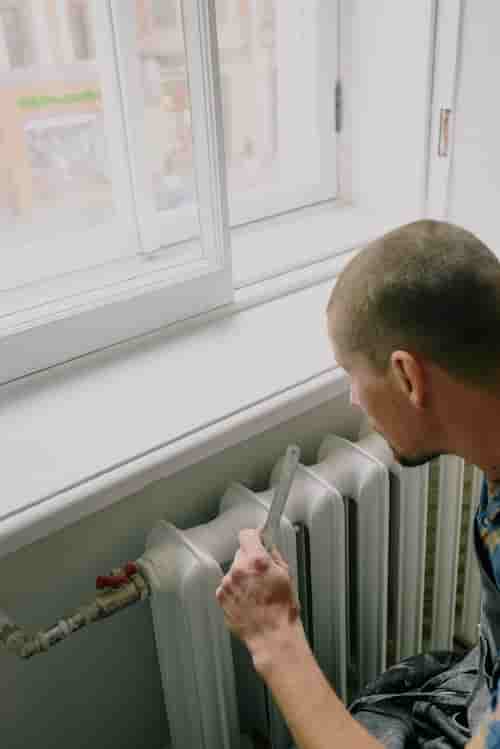Man installing radiator in Exeter